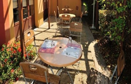 Terrasse du restaurant avec tables rondes et chaises en bois